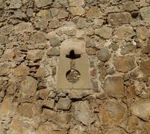 cross sign on aged Stone Wall