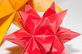 Close-up of the colorful and beautiful origami figures, with shadows on the white surface