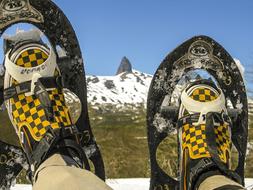 Person wearing snowshoe, laying on the snow, on the mountain, in the winter