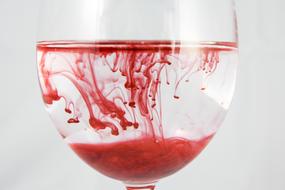 red watercolor in a glass of water