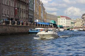 a motor boat floats on a city river