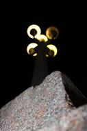 Close-up of the colorful stone wall with the lantern, among the darkness