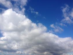 white fluffy clouds in bright blue skies