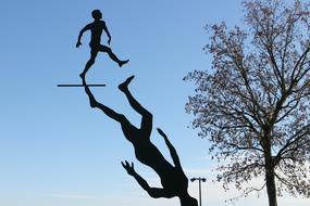 the shadow of a walking man and a tree against the blue sky