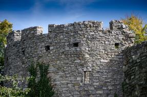 Beautiful walls of the castle, in colorful plants, under the blue sky