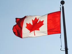 flag of canada on a flagpole against a sky