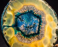 Close-up of the colorful and beautiful agate slice with shapes, at dark background
