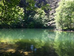 Beautiful landscape of the lake, among the colorful plants, with reflections