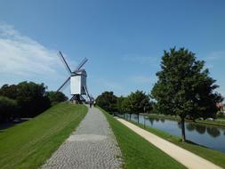 distant view of a mill near a canal in belgium