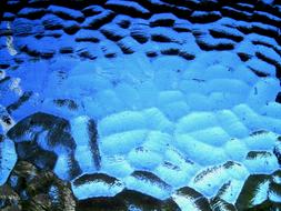 Texture of the shiny, blue, mottled window glass of different shades