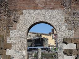 Beautiful cityscape with the stone wall with arch, in Rome, Italy, under the blue sky