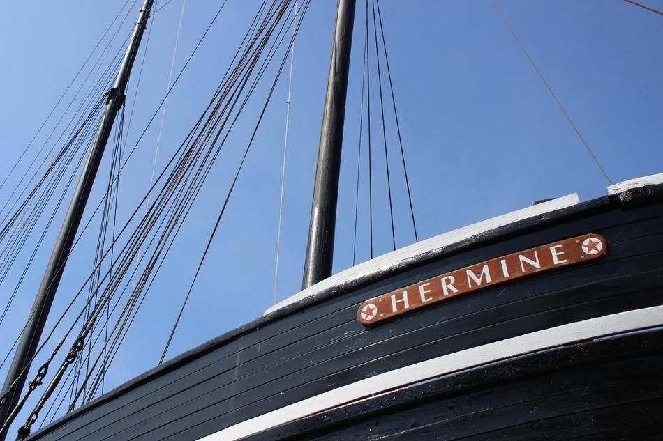 Colorful 'Hermine' barge ship with sign in sunlight, under the blue sky