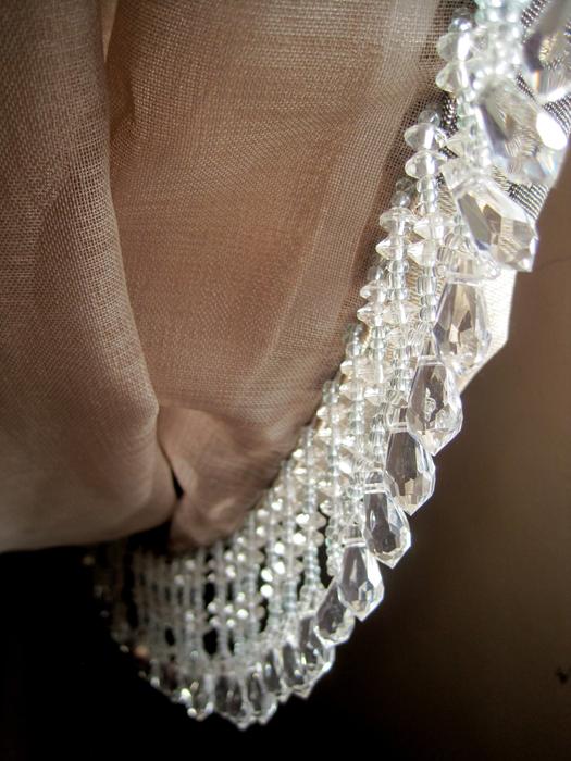 Close-up of the brown curtain with beautiful, white ornaments