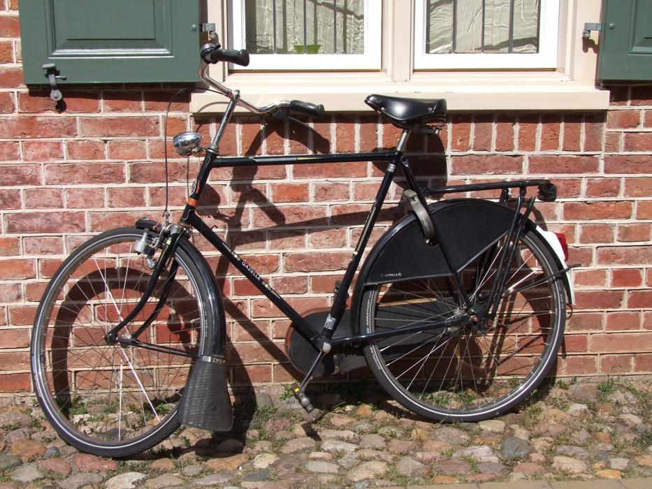 Black bike near the brick building with windows