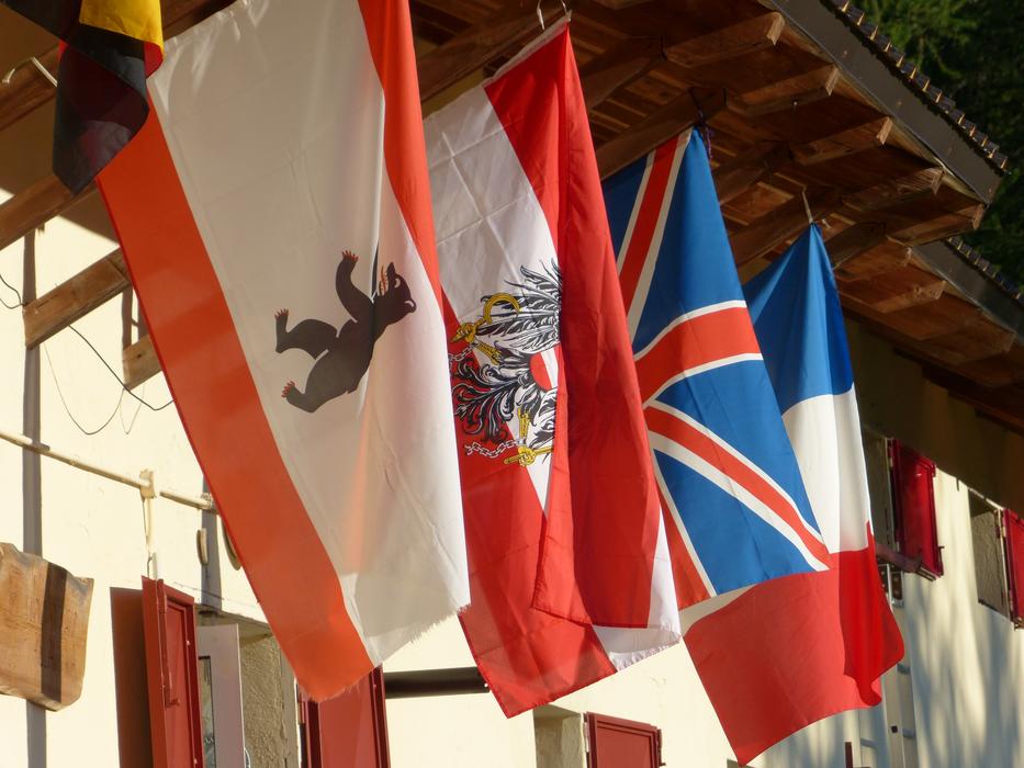 Colorful flags of Austria, England and France, on the building