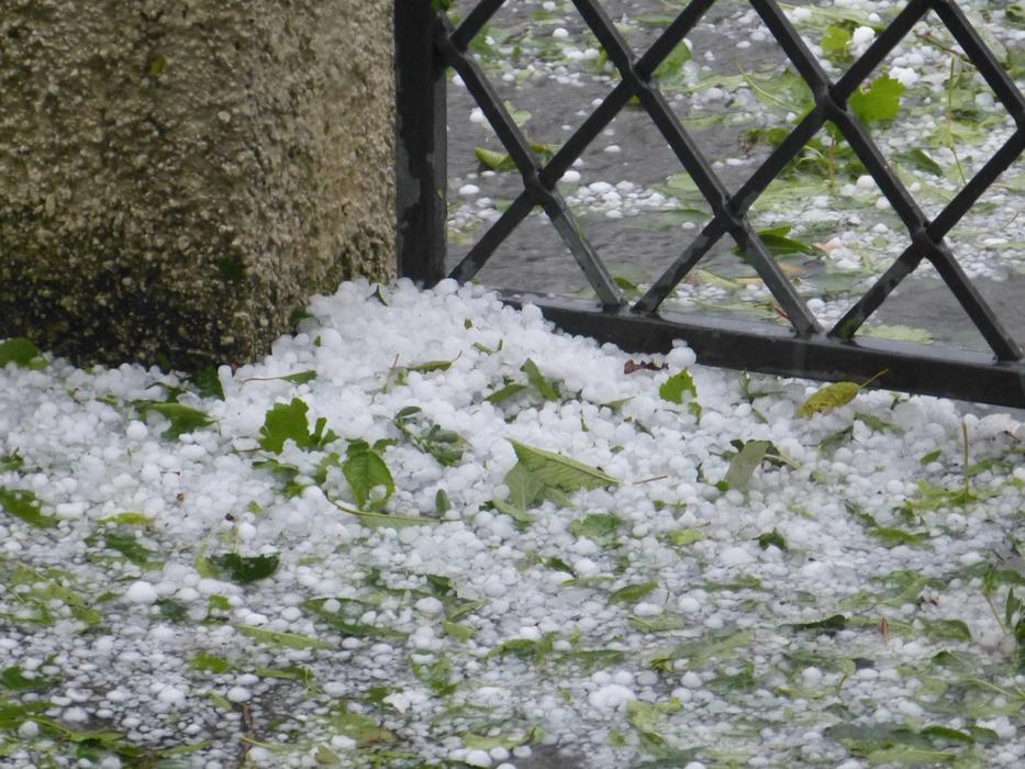 Close-up of the pile of hail ice pieces, near the fence