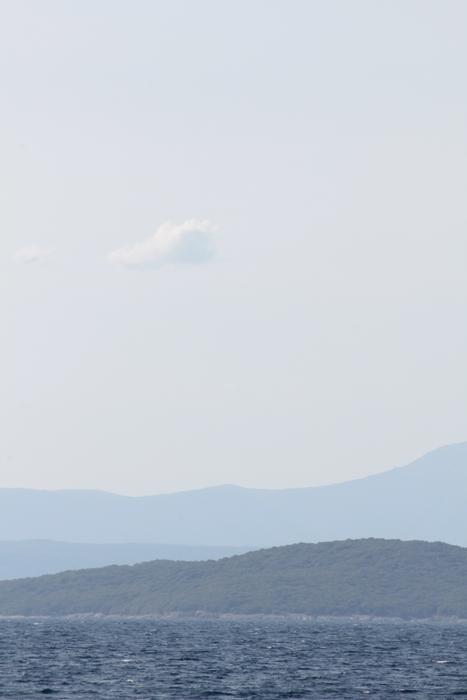 silhouettes of mountains above the water on the horizon