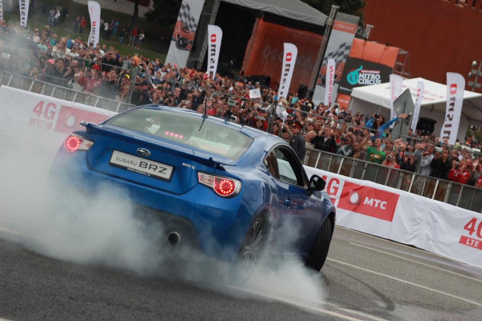 Beautiful, blue 'Subaru' car driving on the track, in Russia, with spectators