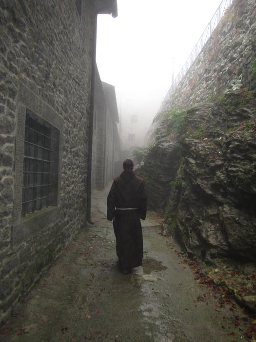 Monk near the monastery, on the beautiful landscape in fog