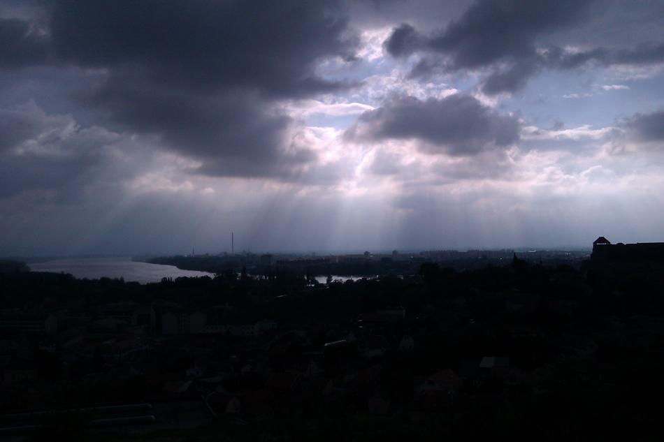 sun behind the clouds over the lake in the evening