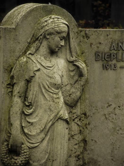 Statue of the woman, near the sign, on the gravestone