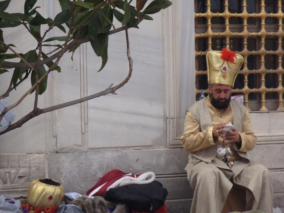 the king is sitting in the street near the window