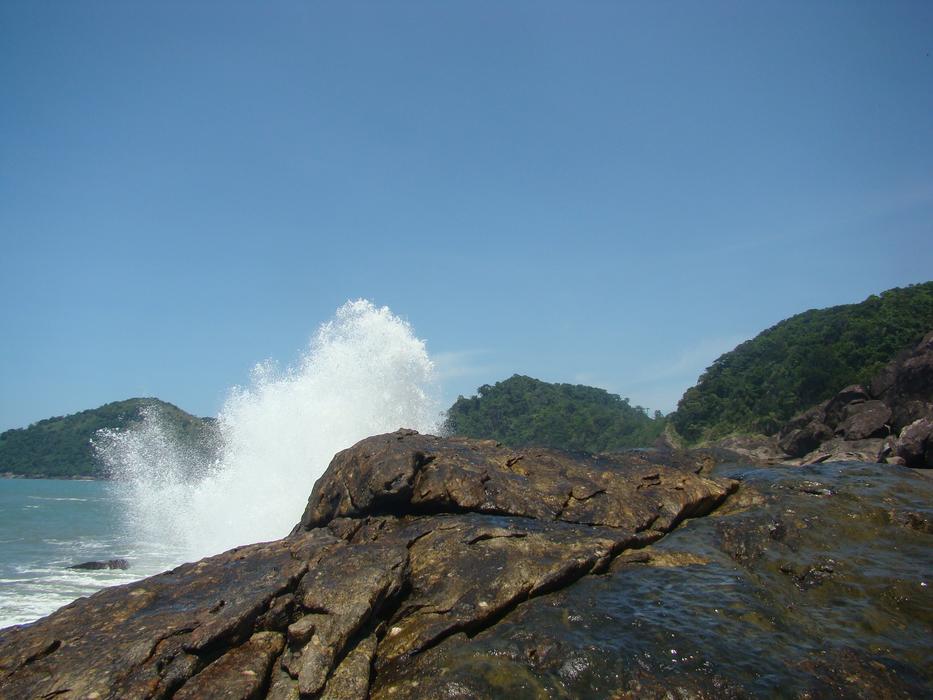 Beautiful rocky coast with waves, under the blue sky