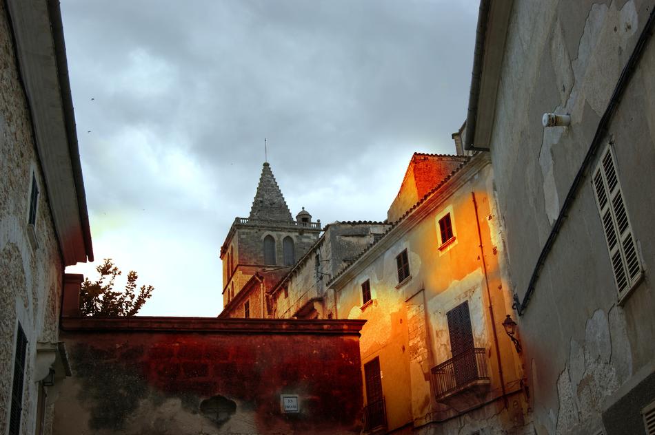 Buildings in colorful lights, in Sineu, Balearic Islands, under the clouds