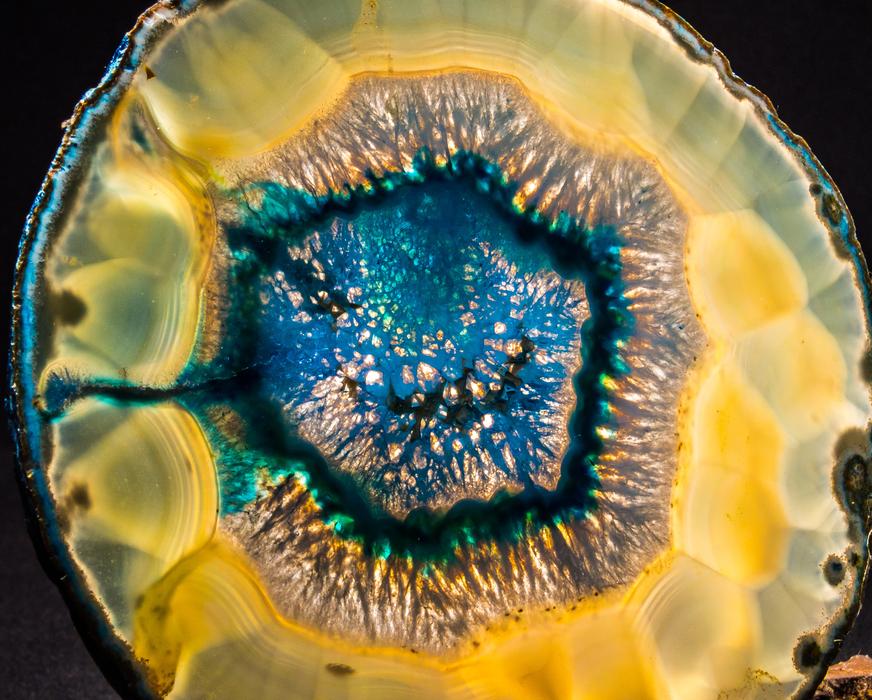 Close-up of the colorful and beautiful agate slice with shapes, at dark background