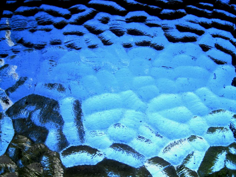 Texture of the shiny, blue, mottled window glass of different shades