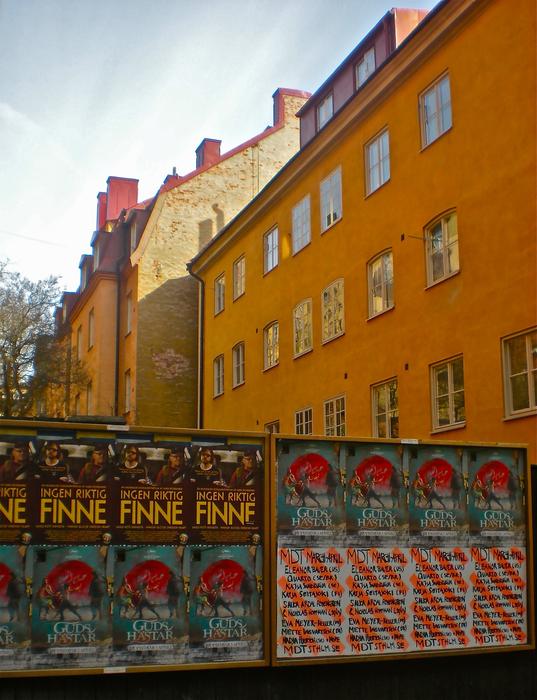 yellow building facade and posters on the fence in Stockholm