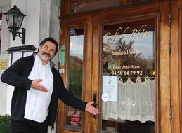 smiling man at entrance of restaurant