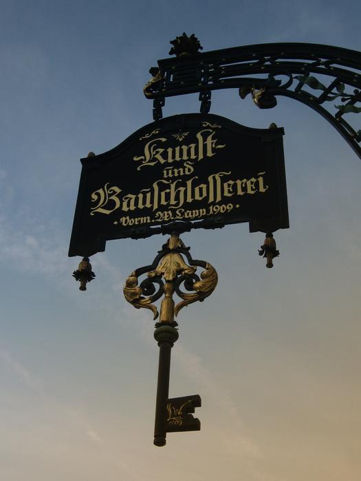 forged key on the sign above the workshop