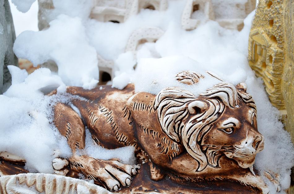 snow on lioness sculpture