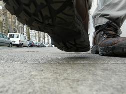 male feet walking on asphalt road Close Up