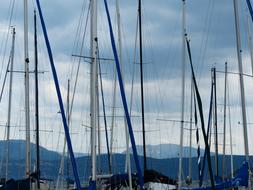 masts of sailing ships against the background of the cloudy sky