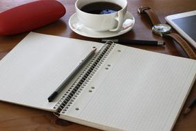 notebook on table with mug
