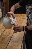 man pours coffee from kettle