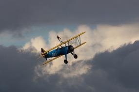 vintage Biplane Flying at cloudy sky