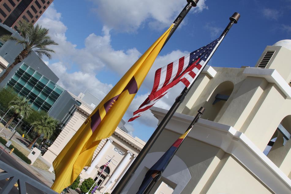 Arizona State University Flag on pole near american flag in city, usa