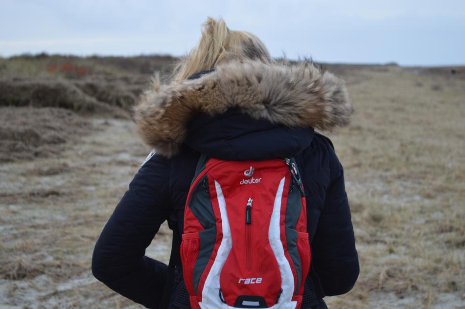 girl with a red backpack and a jacket with a hood