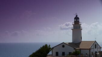 Lighthouse by the Water Sea at sunset