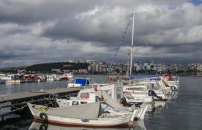 boats moored at pier in view of coastal city