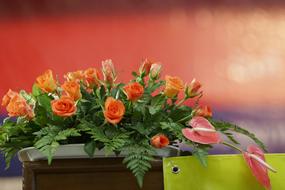 Beautiful, red, orange and white roses in the bouquet with flowers and decorations