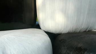 stack of Round Hay Bales in white and black wrapping