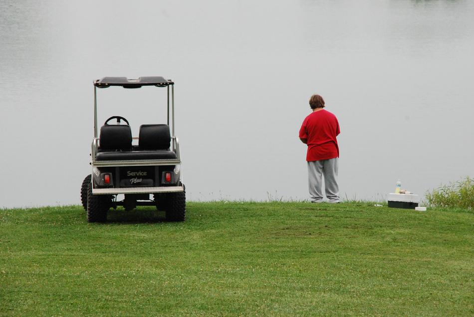 man next to a golf car