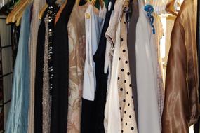 women's clothes hanging on hangers in the laundry room