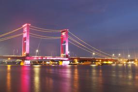 illuminated bridge over musi river, palembang, indonesia