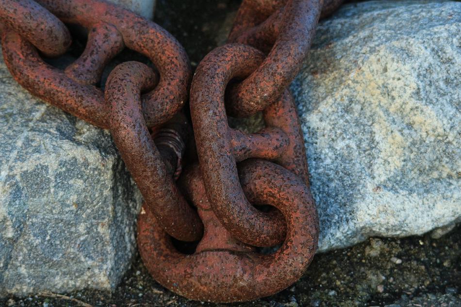 stones and rusty anchor chain