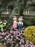 a pair of sculptures of a boy and a girl in the garden